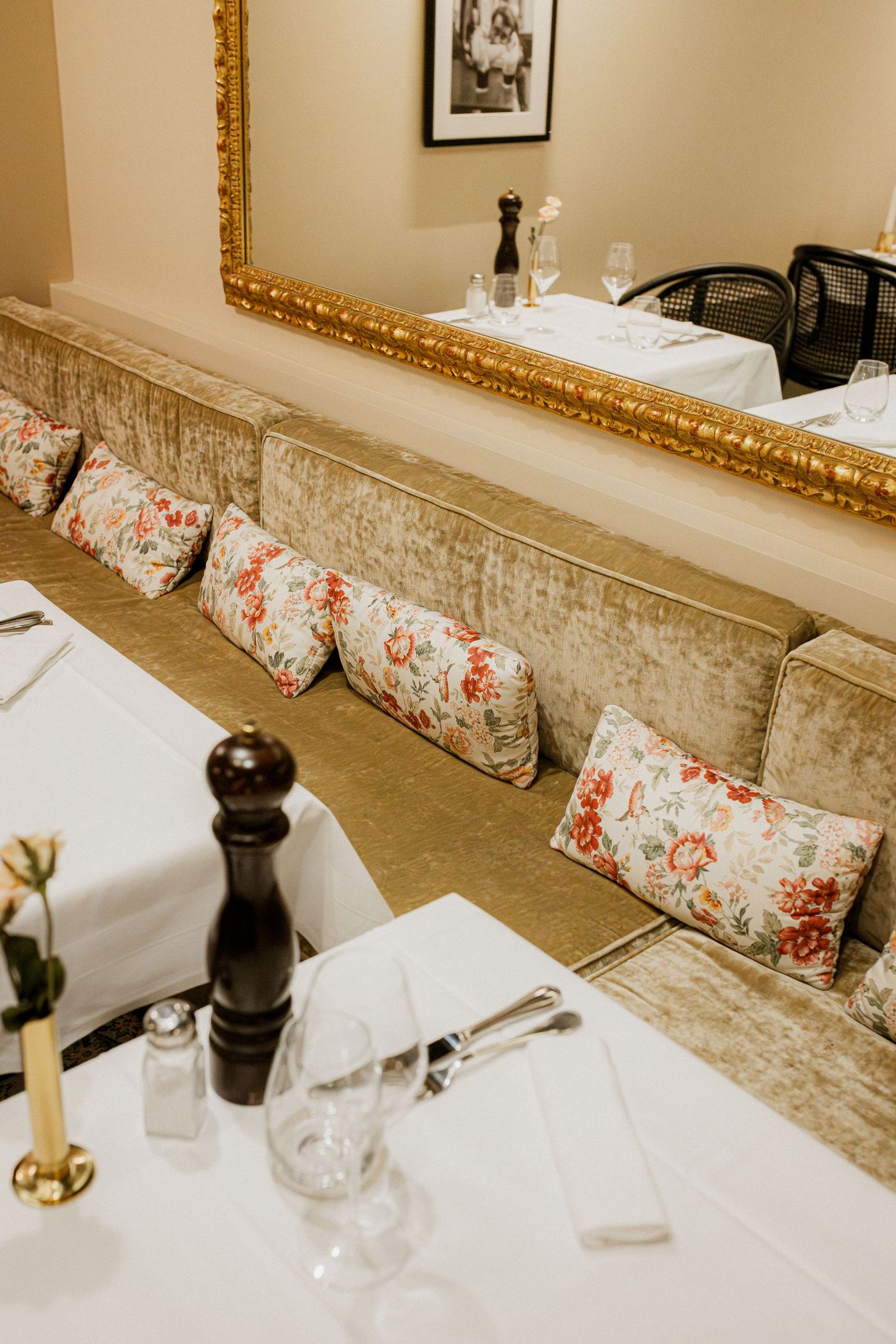 Les banquettes de velours champagne et le miroir doré de la Villa Léonard, le soir
