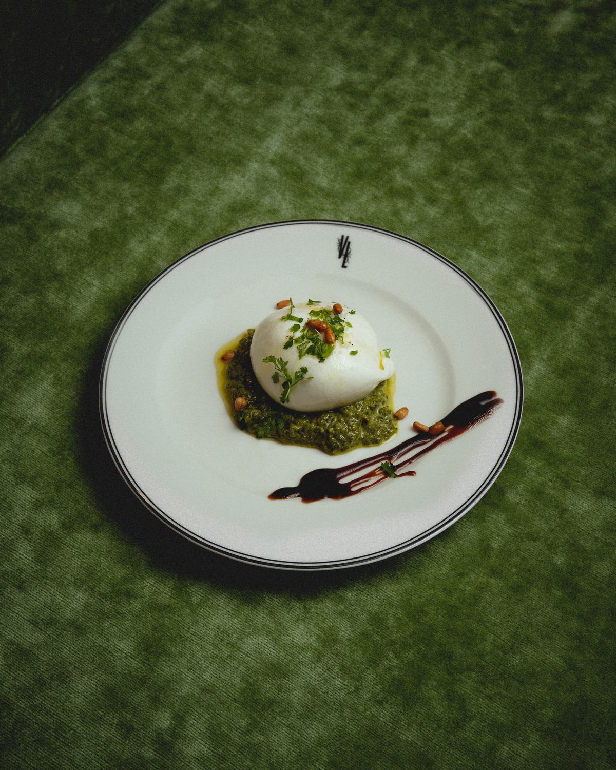 Burrata au pesto et pignons de pin, dressée sur le velours vert de la Villa Léonard