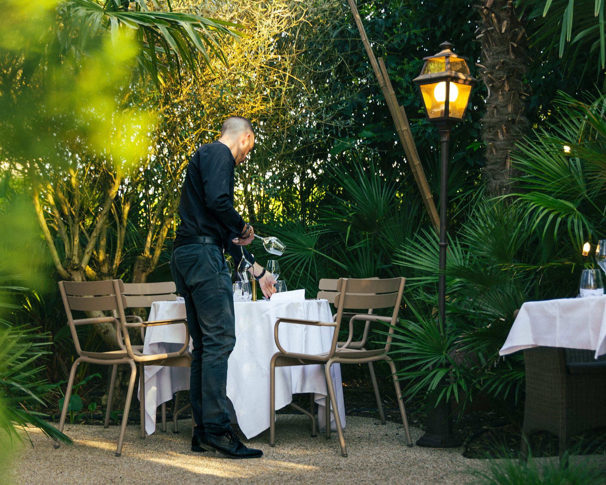 Le jardin-terrasse de la Villa Léonard à Bois-Guillaume, tables nappées de blanc sous les palmiers