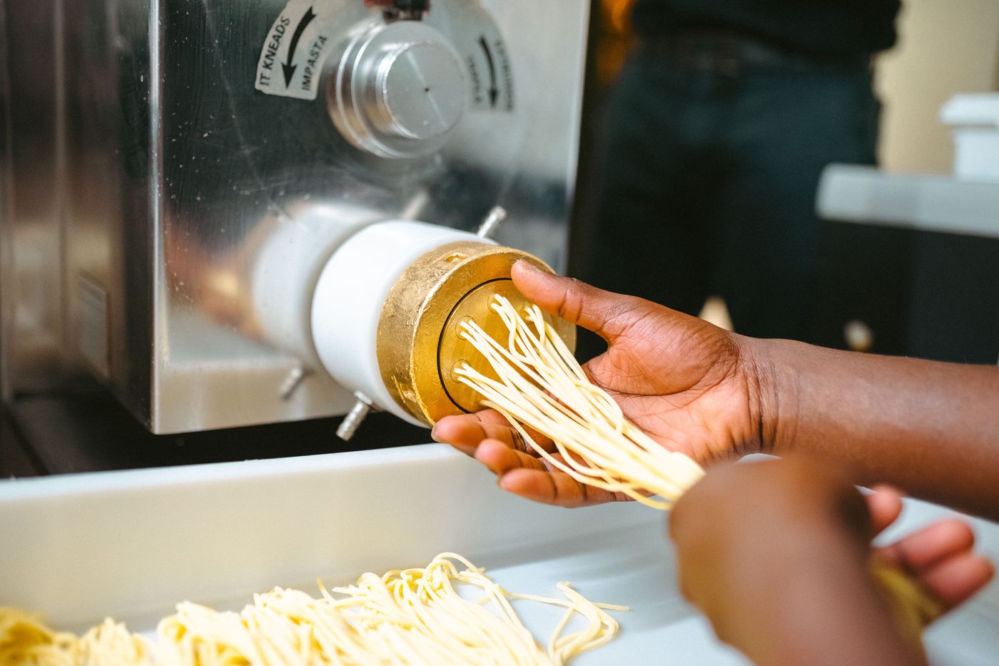 Les pâtes fraîches sortent de la machine en bronze, à la main, en cuisine